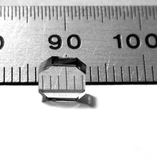 Close-up of a diamond next to a metal ruler