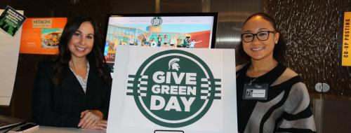 Individuals holding a Give Green Day sign